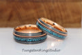 May include: Two tungsten carbide wedding bands with a rose gold inlay and turquoise inlay. The bands are both beveled and have a brushed finish.