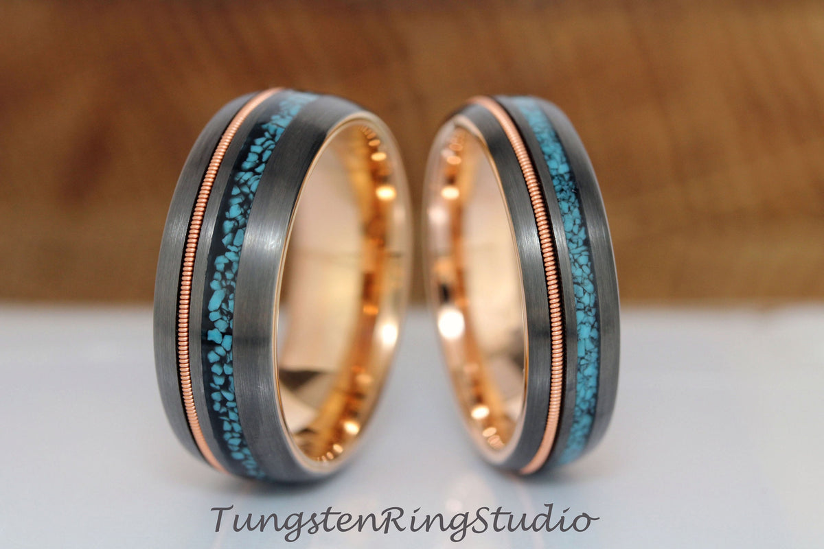 May include: Two tungsten carbide rings with a rose gold inlay and a turquoise inlay. The rings are both brushed and have a matte finish.