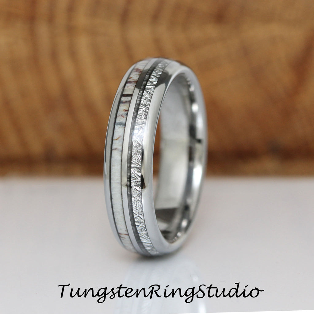 May include: A silver tungsten ring with a white and brown inlay. The inlay is made of deer antler and meteorite.