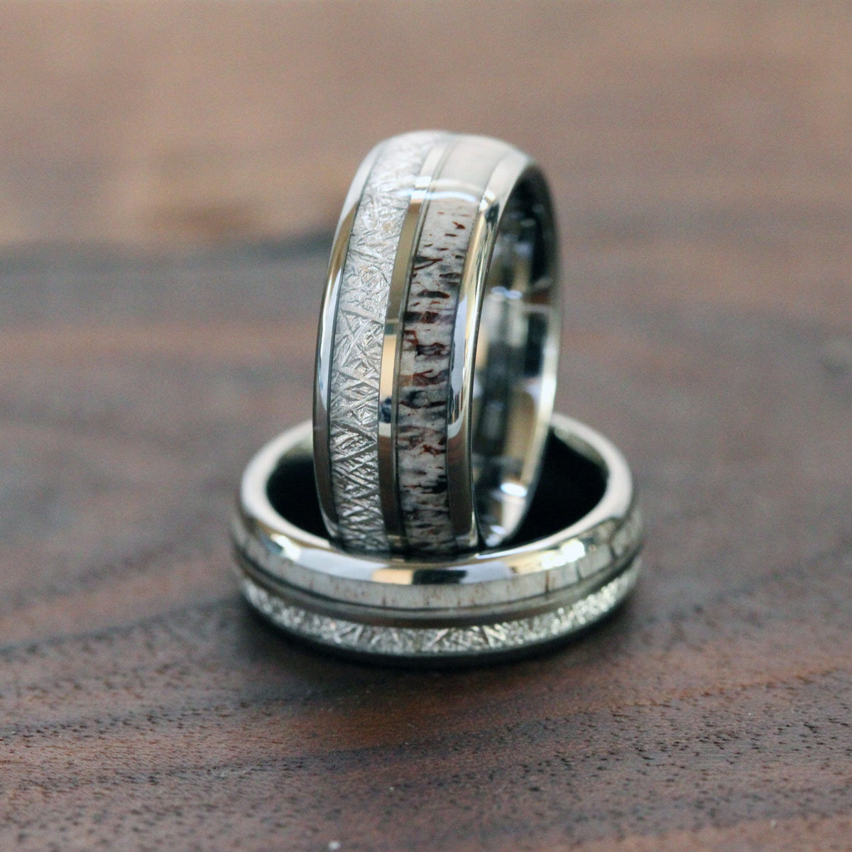 May include: Two silver wedding bands with a white and brown antler inlay. The bands are stacked on top of each other.