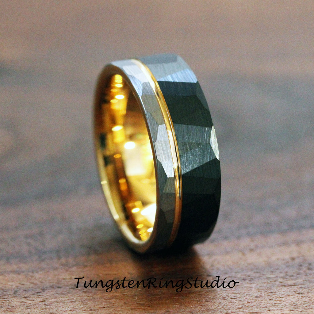 May include: A tungsten carbide ring with a hammered finish and a gold band. The ring is a dark gray color and has a brushed finish.