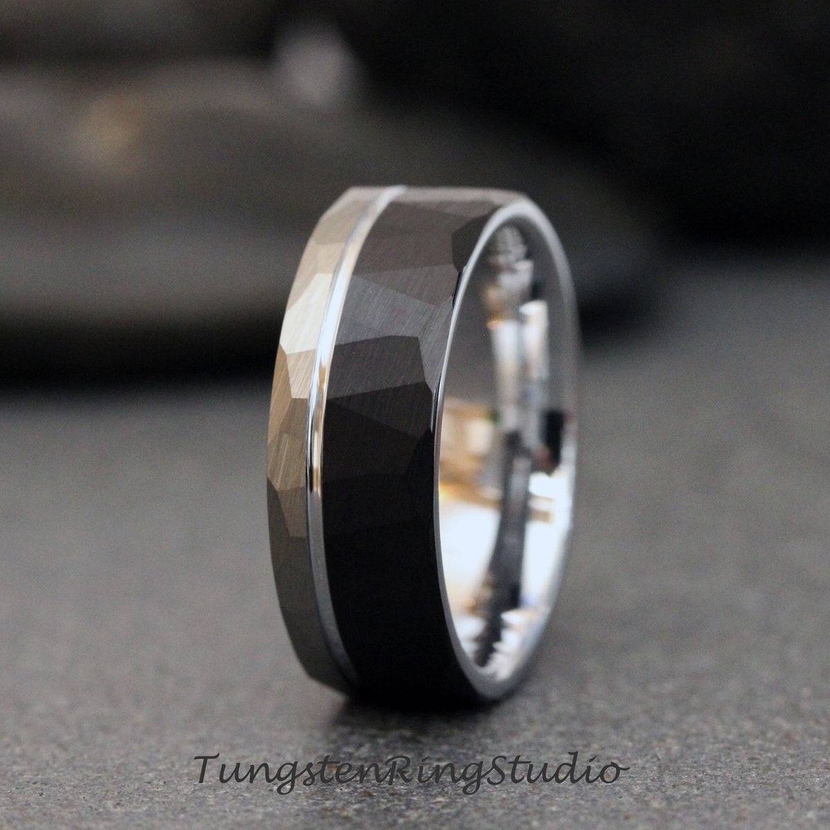 May include: A black tungsten carbide ring with a silver band. The ring has a hammered finish and a beveled edge.