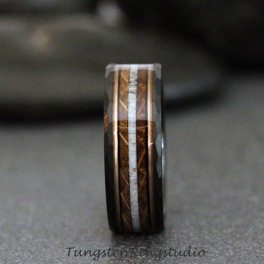 May include: A black tungsten ring with a rose gold inlay and a wood and white bone inlay. The ring has a beveled edge.