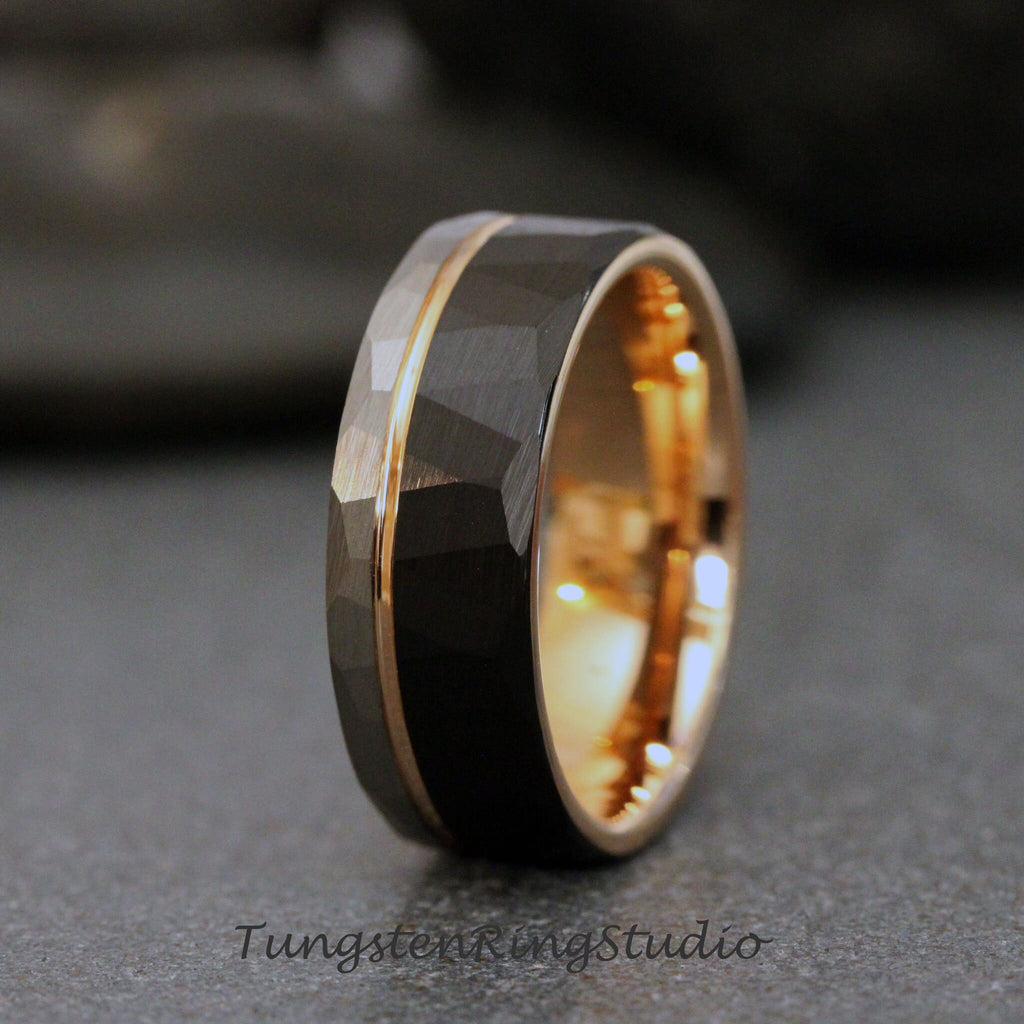 May include: A black tungsten carbide ring with a rose gold band and a hammered finish.