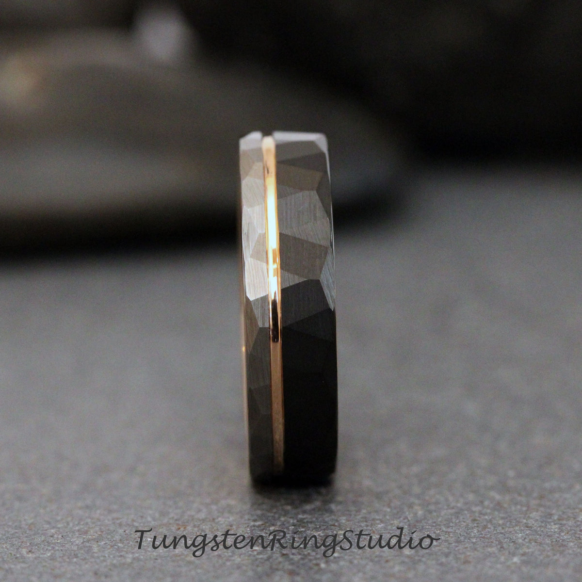 May include: A black tungsten carbide ring with a gold inlay. The ring has a hammered finish and a beveled edge.