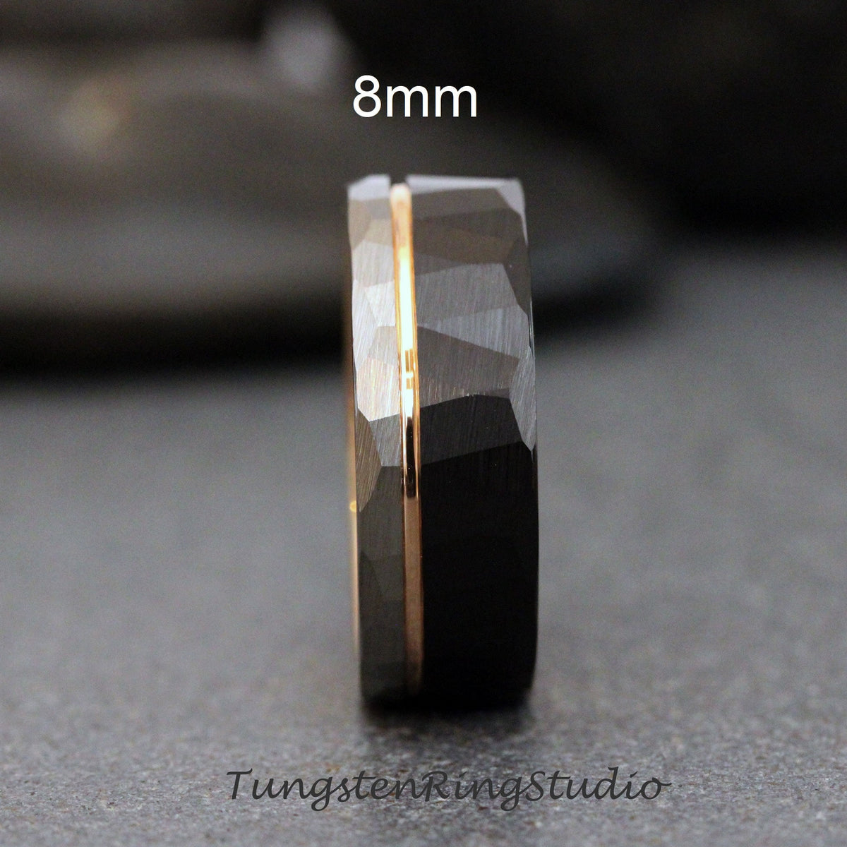 May include: A black tungsten carbide ring with a gold inlay. The ring is 8mm wide and has a hammered finish.