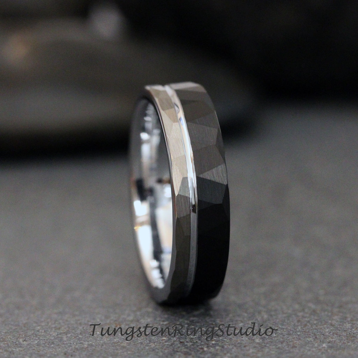 May include: A black tungsten carbide ring with a silver band and a hammered finish.