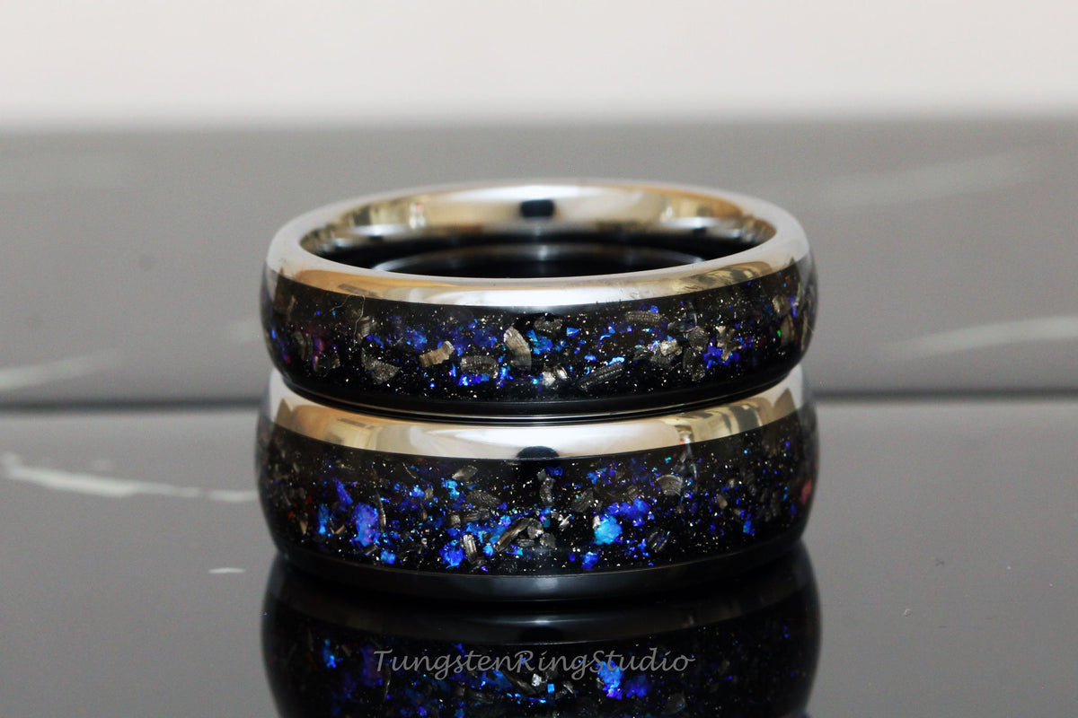 May include: Two stacked tungsten carbide rings with a black and blue galaxy-inspired design. The rings have a silver-colored band.
