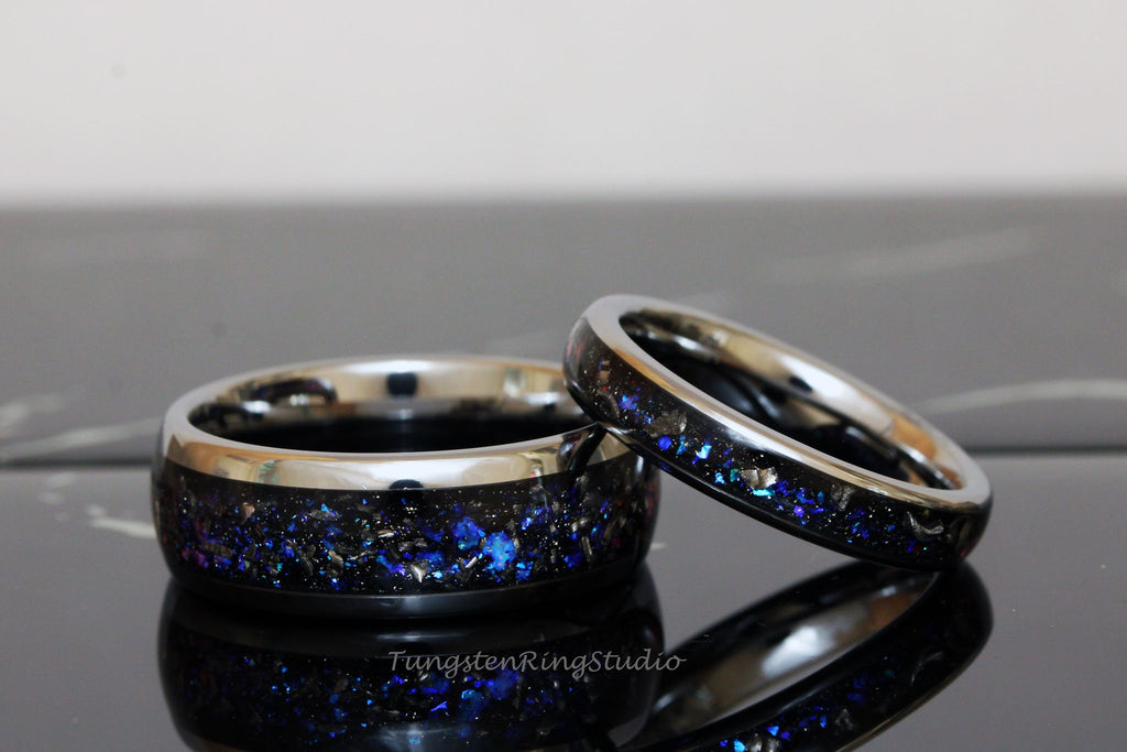 May include: Two matching tungsten carbide rings with a black band and a blue glitter inlay. The rings are stacked on top of each other.