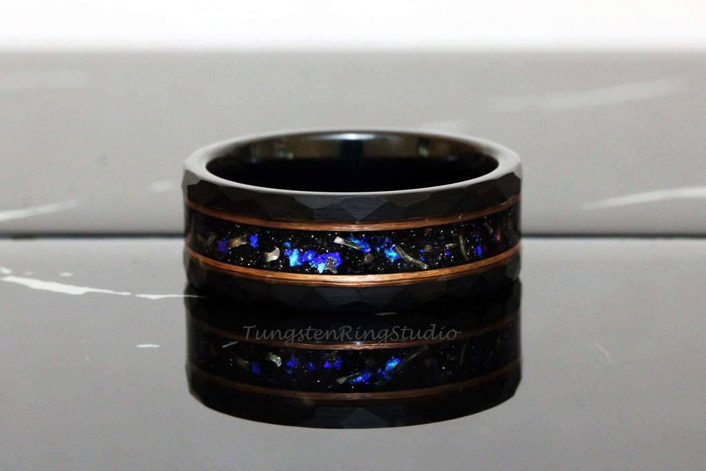May include: Black tungsten carbide ring with a copper inlay and blue and silver glitter embedded in the inlay. The ring has a hammered finish.