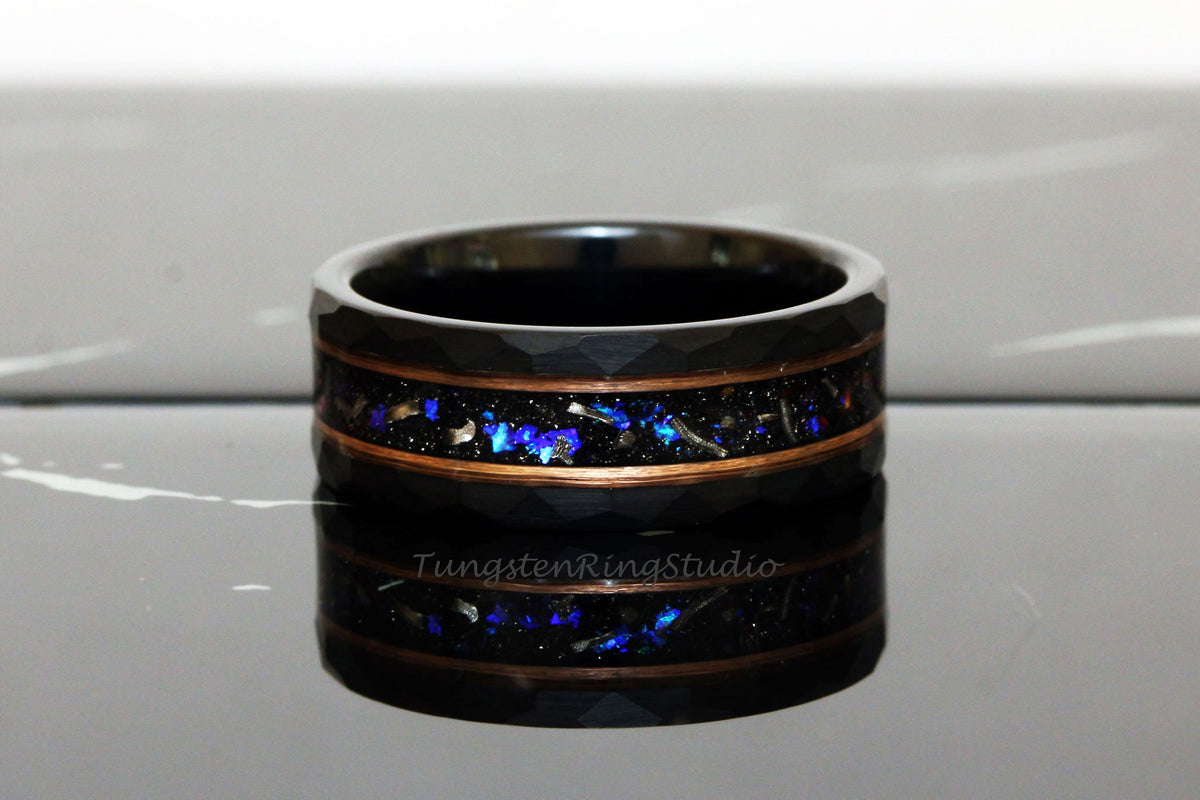 May include: Black tungsten carbide ring with a copper inlay and blue and silver glitter embedded in the inlay. The ring has a hammered finish.