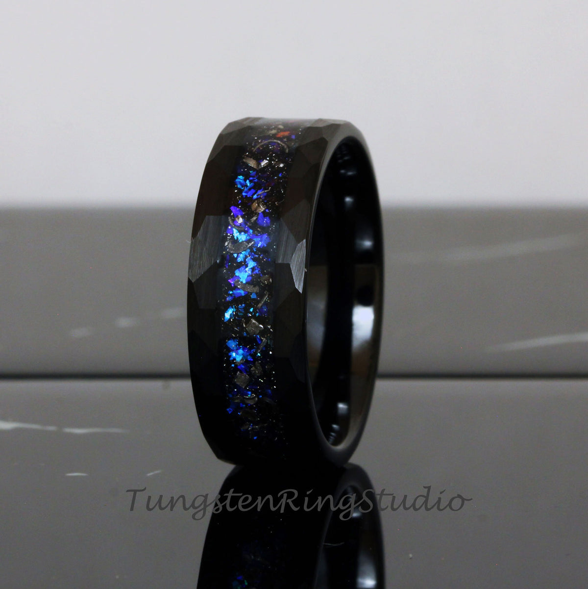 May include: Black tungsten carbide ring with a hammered finish and a blue and silver glitter inlay.