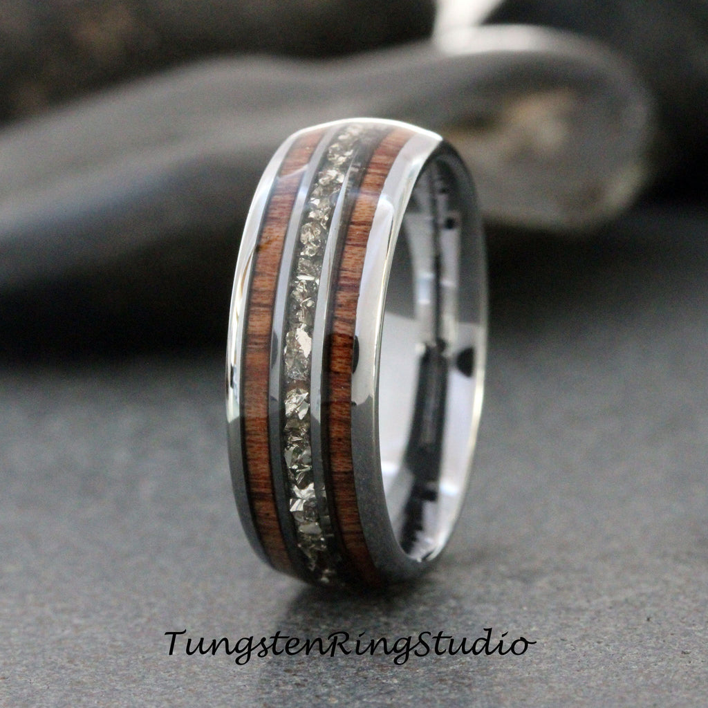 May include: A silver tungsten carbide ring with a brown wood inlay and a row of small clear stones.