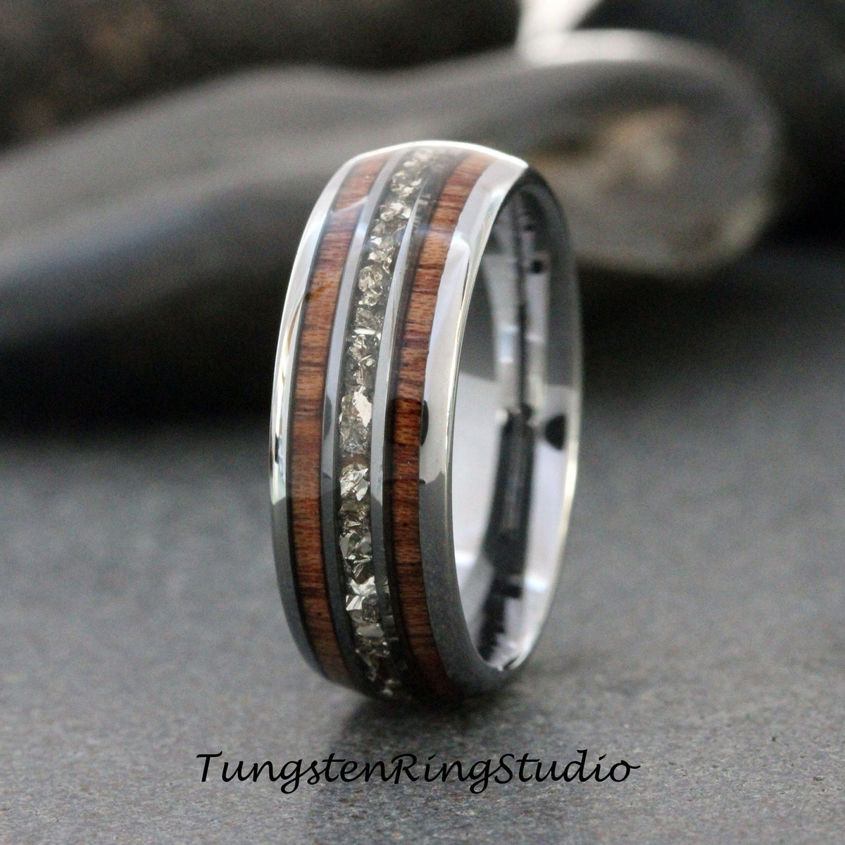 May include: A silver tungsten carbide ring with a brown wood inlay and a row of small clear stones.
