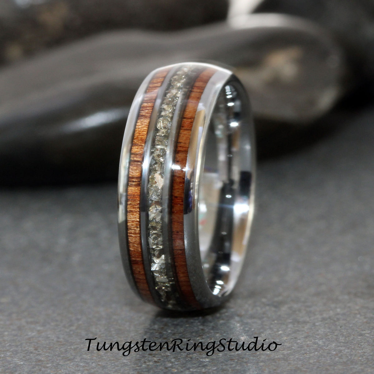 May include: A silver tungsten ring with a band of dark wood and a row of small, clear stones.
