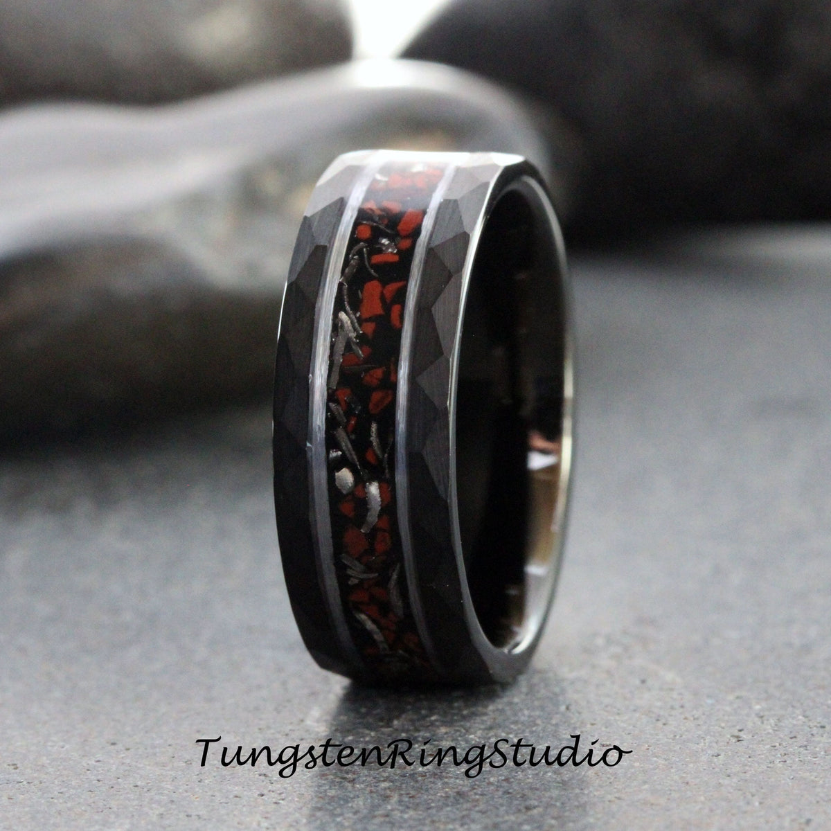 May include: A black tungsten carbide ring with a red and silver inlay. The ring has a beveled edge and a brushed finish.