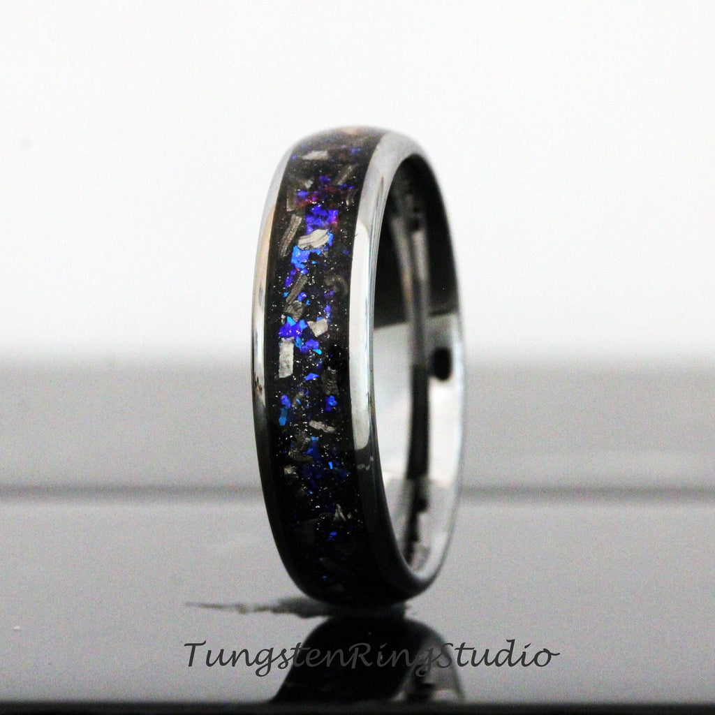 May include: A black tungsten ring with a blue and silver inlay. The ring has a polished finish and a comfortable fit.