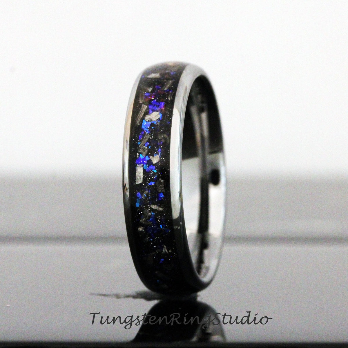May include: A black tungsten ring with a blue and silver inlay. The ring has a polished finish and a comfortable fit.
