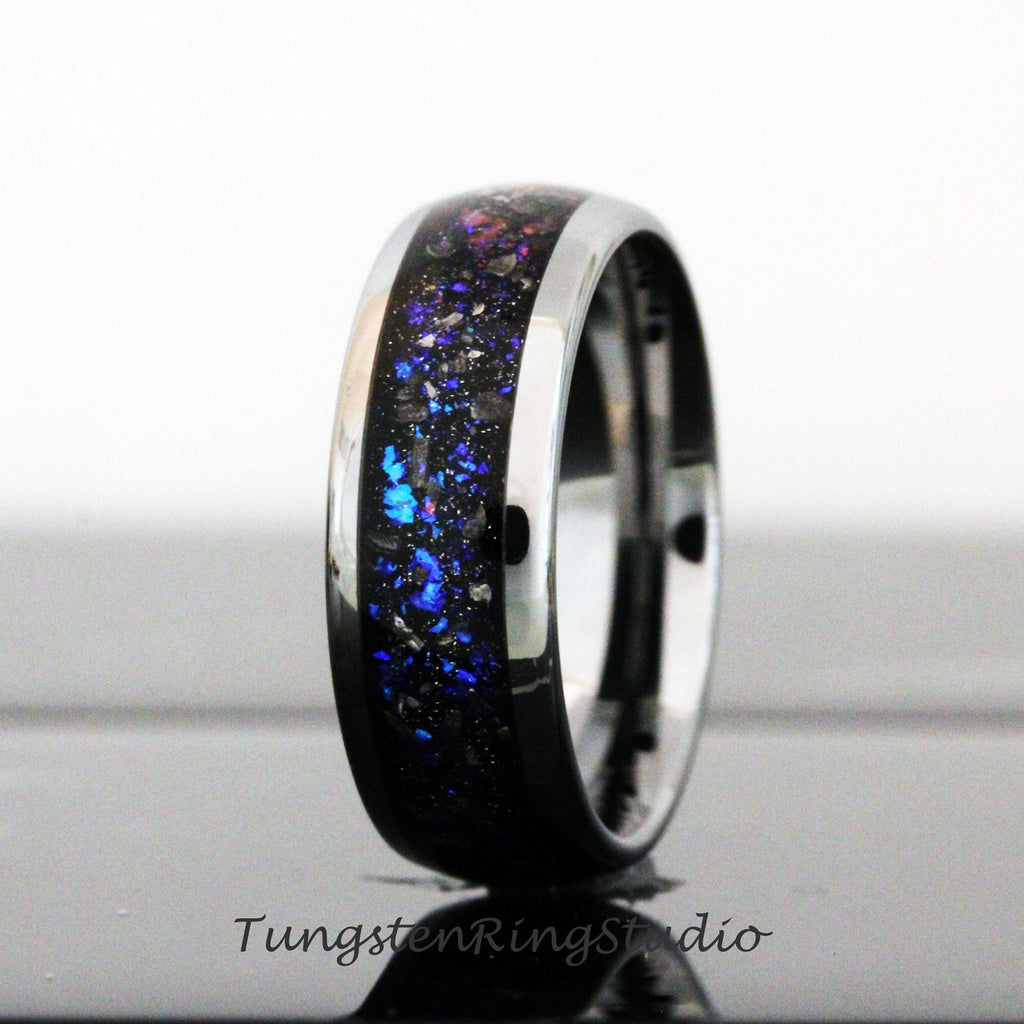 May include: A black tungsten ring with a blue and silver inlay. The inlay has a sparkly, glittery appearance.