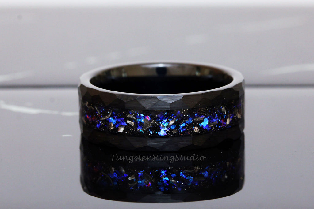 May include: Black tungsten carbide ring with a blue and silver glitter inlay. The ring has a brushed finish and a beveled edge.