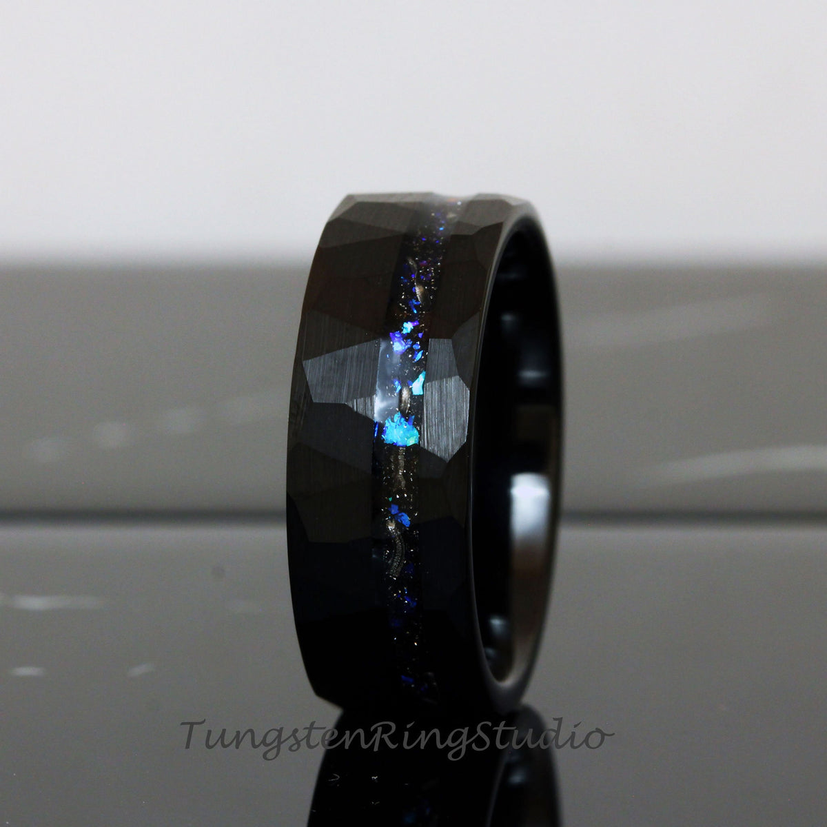May include: Black tungsten carbide ring with a hammered finish and a blue and silver glitter inlay.