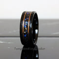 May include: A black tungsten carbide ring with a hammered finish and a copper inlay. The inlay is filled with blue and silver glitter.