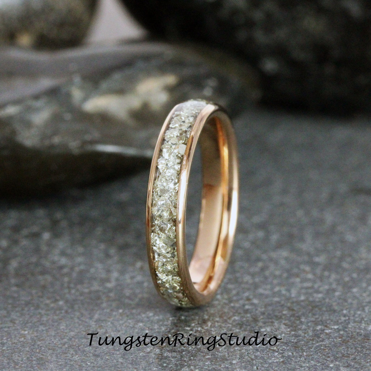 May include: A rose gold tungsten carbide ring with a band of small diamonds.
