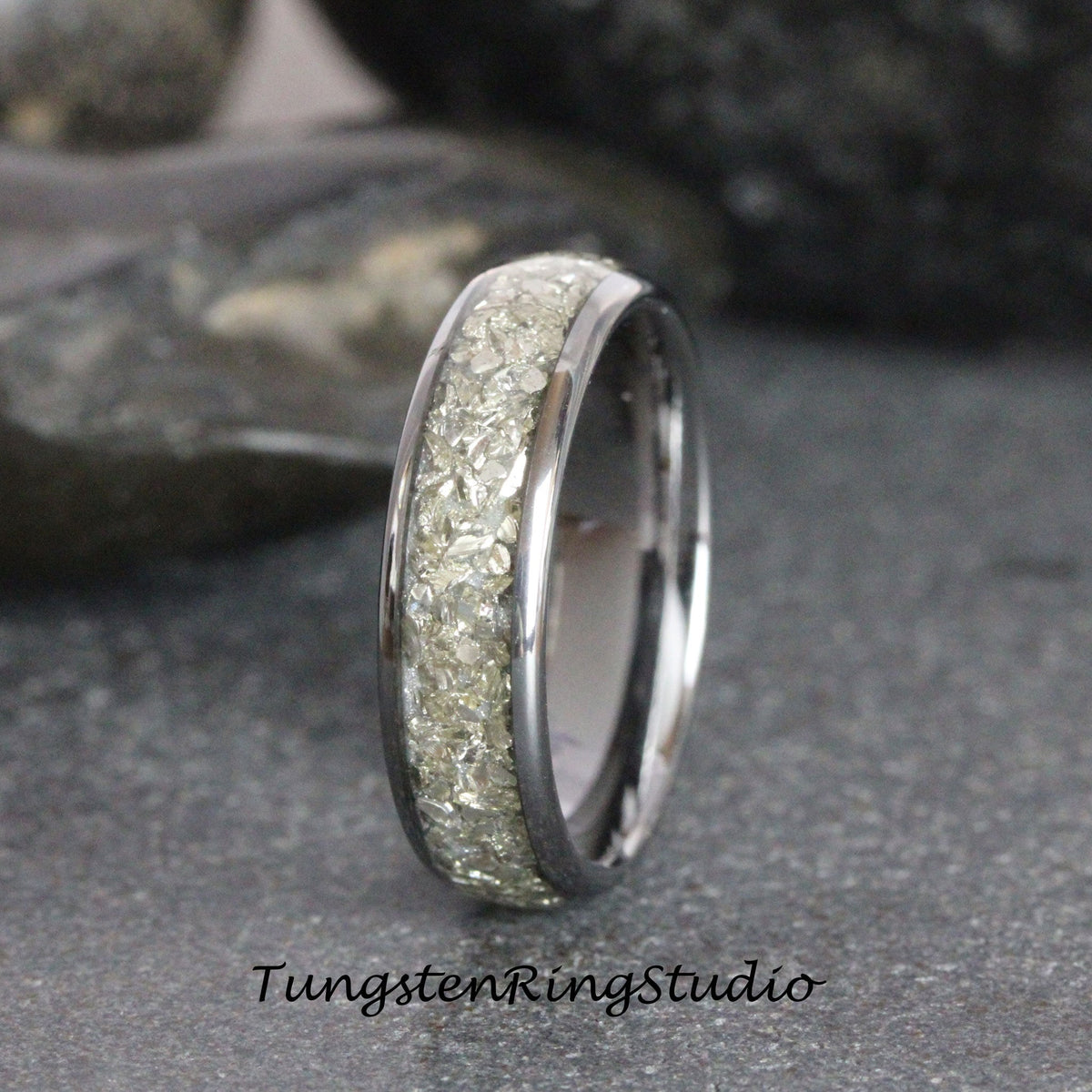 May include: A silver tungsten carbide ring with a band of embedded white diamonds. The ring is a classic style and is perfect for a wedding band or an engagement ring.
