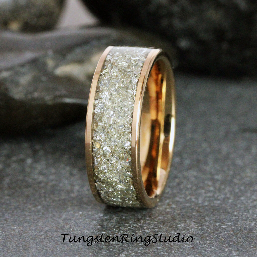 May include: A rose gold tungsten carbide ring with a band of embedded white diamonds. The ring is a classic wedding band style.
