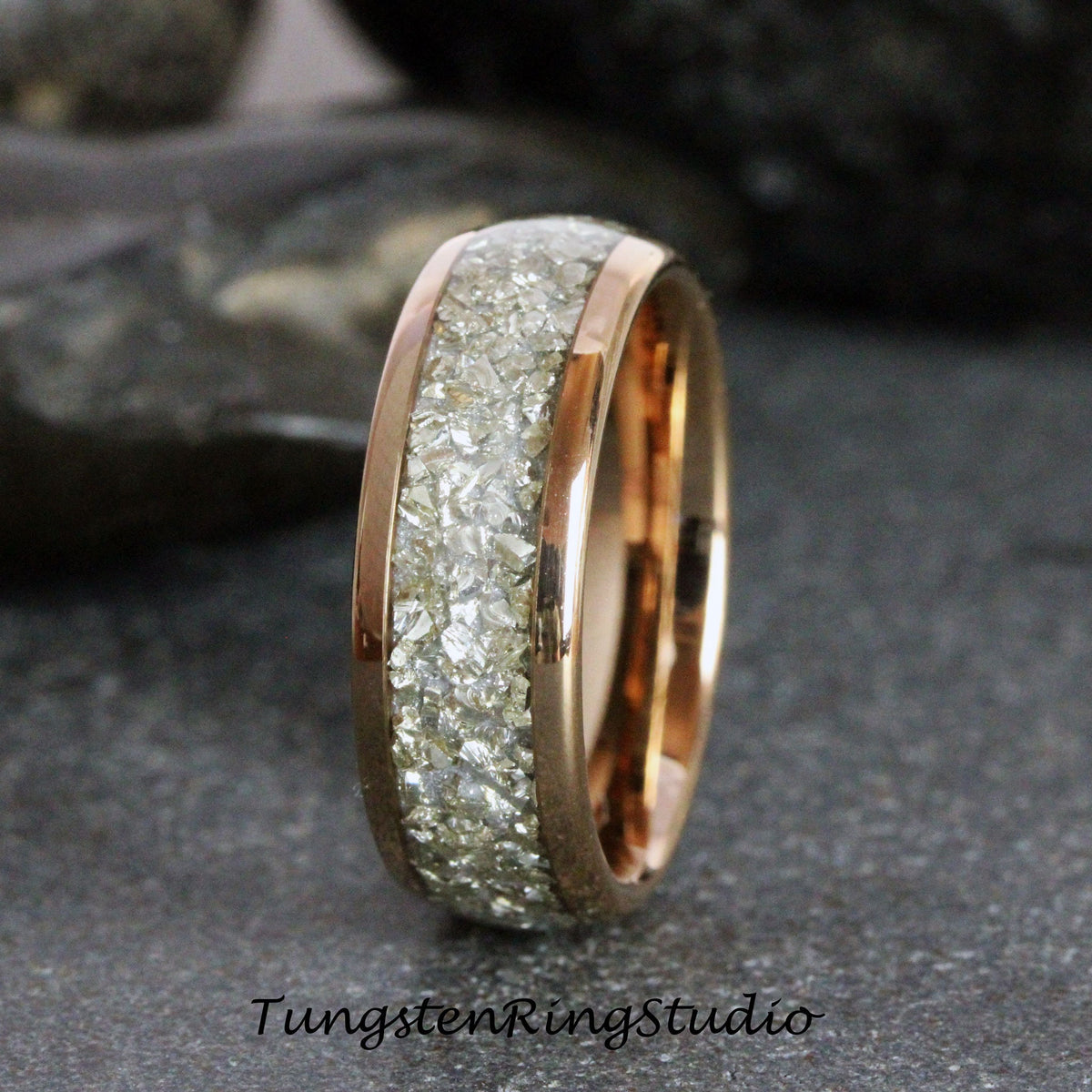 May include: A rose gold tungsten carbide ring with a band of embedded white diamonds.