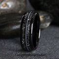 May include: A black tungsten carbide ring with a silver inlay design. The ring has a polished finish and a comfortable fit.