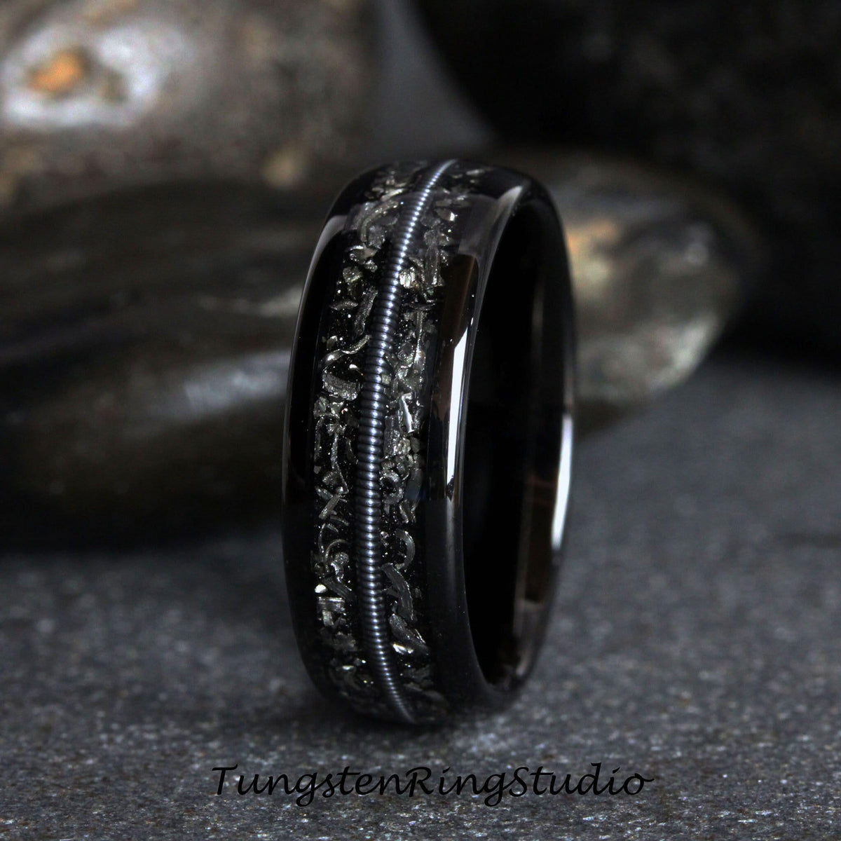 May include: A black tungsten carbide ring with a silver inlay design. The ring has a polished finish and a comfortable fit.