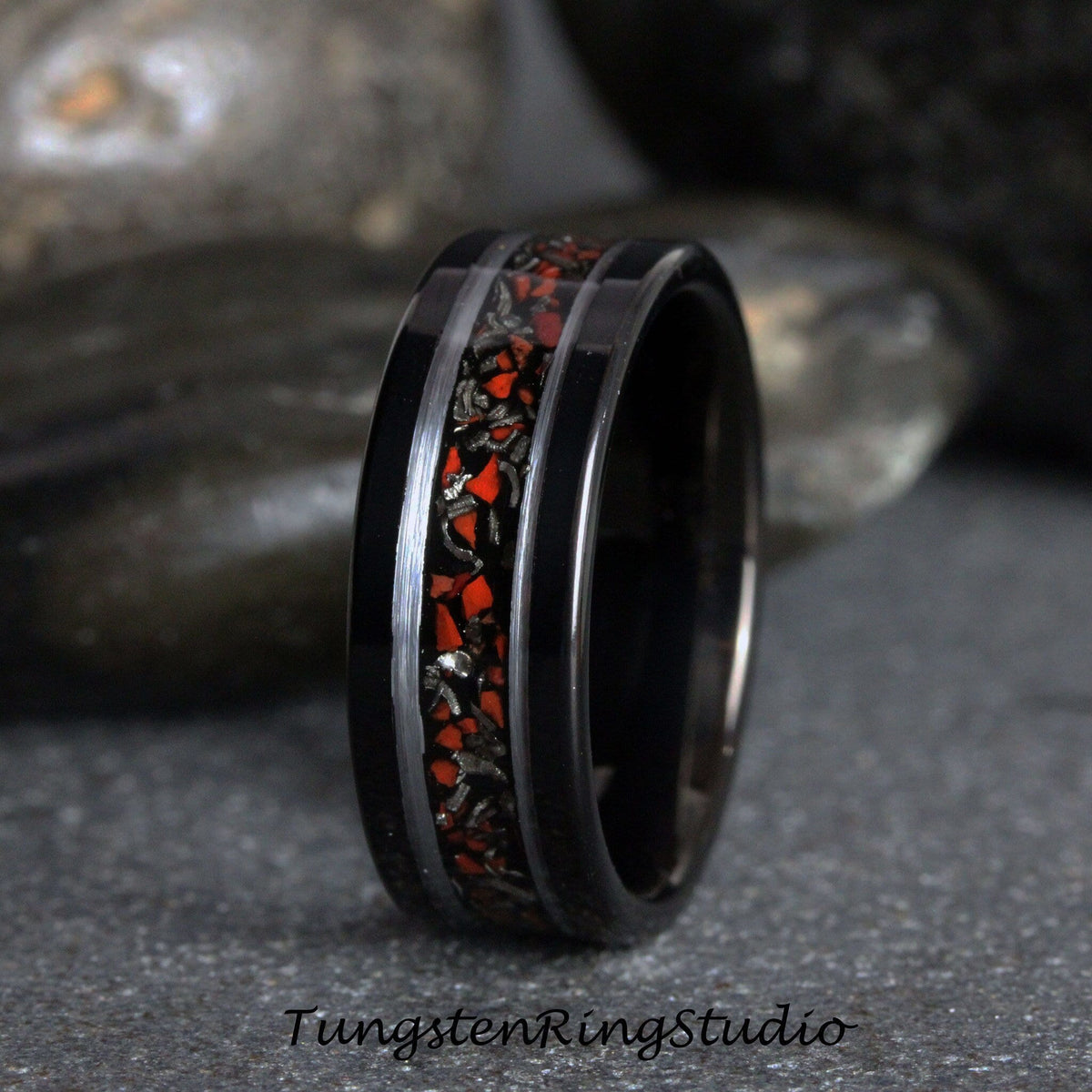 May include: Black tungsten carbide ring with a red and silver inlay. The ring has a polished finish and a beveled edge.