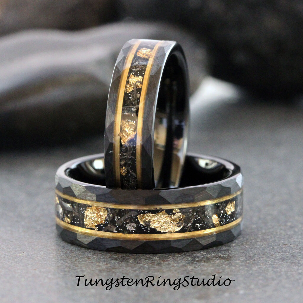 May include: Two black tungsten carbide rings with a gold inlay and a hammered finish. The rings are stacked on top of each other.