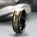 May include: A black tungsten carbide ring with a gold inlay featuring a scattered pattern of gold flakes. The ring has a polished finish.