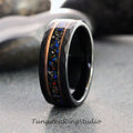 May include: A black tungsten ring with a faceted exterior and a central inlay of colorful, sparkling material. The inlay is framed by copper-colored metal bands. The ring is displayed on a gray surface. The text "TungstenRingStudio" is at the bottom.