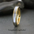 May include: A silver and gold wedding band with a white inlay. The band is polished and has a smooth finish.