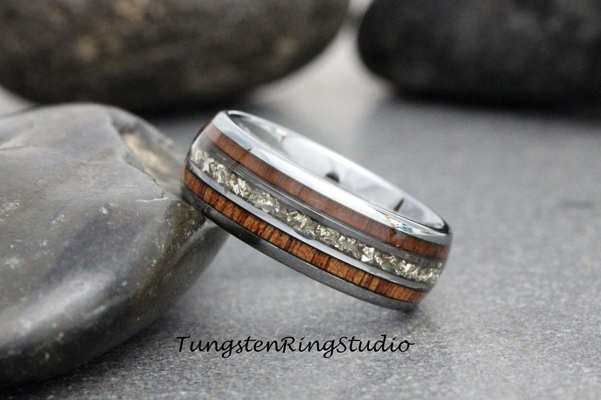 May include: A silver tungsten ring with a brown wood inlay and a row of small diamonds.