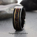 May include: A black tungsten carbide ring with a gold inlay and red and black speckled inlay. The ring is a wedding band.