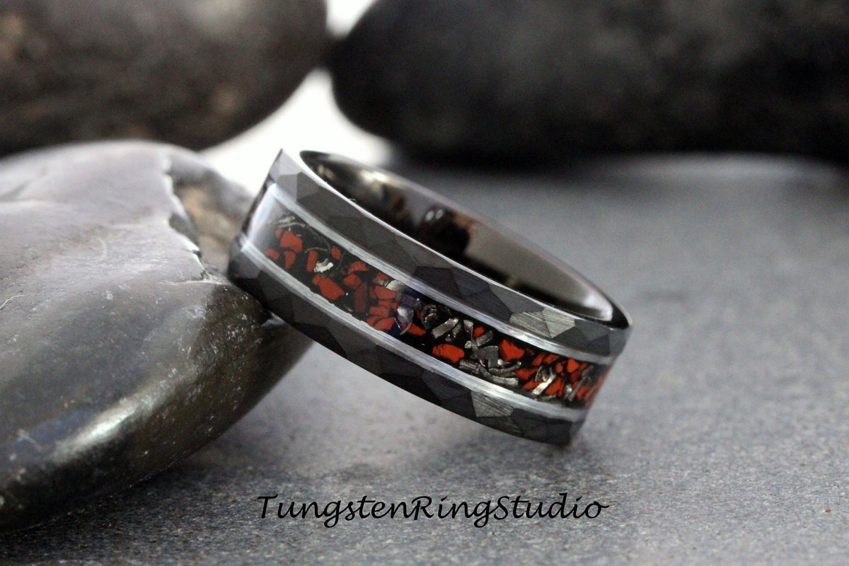 May include: A black tungsten ring with a red and silver inlay. The ring has a hammered finish and a beveled edge.