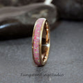 May include: A thin rose gold tungsten carbide ring with a pink opal inlay. The ring is polished and has a smooth finish.
