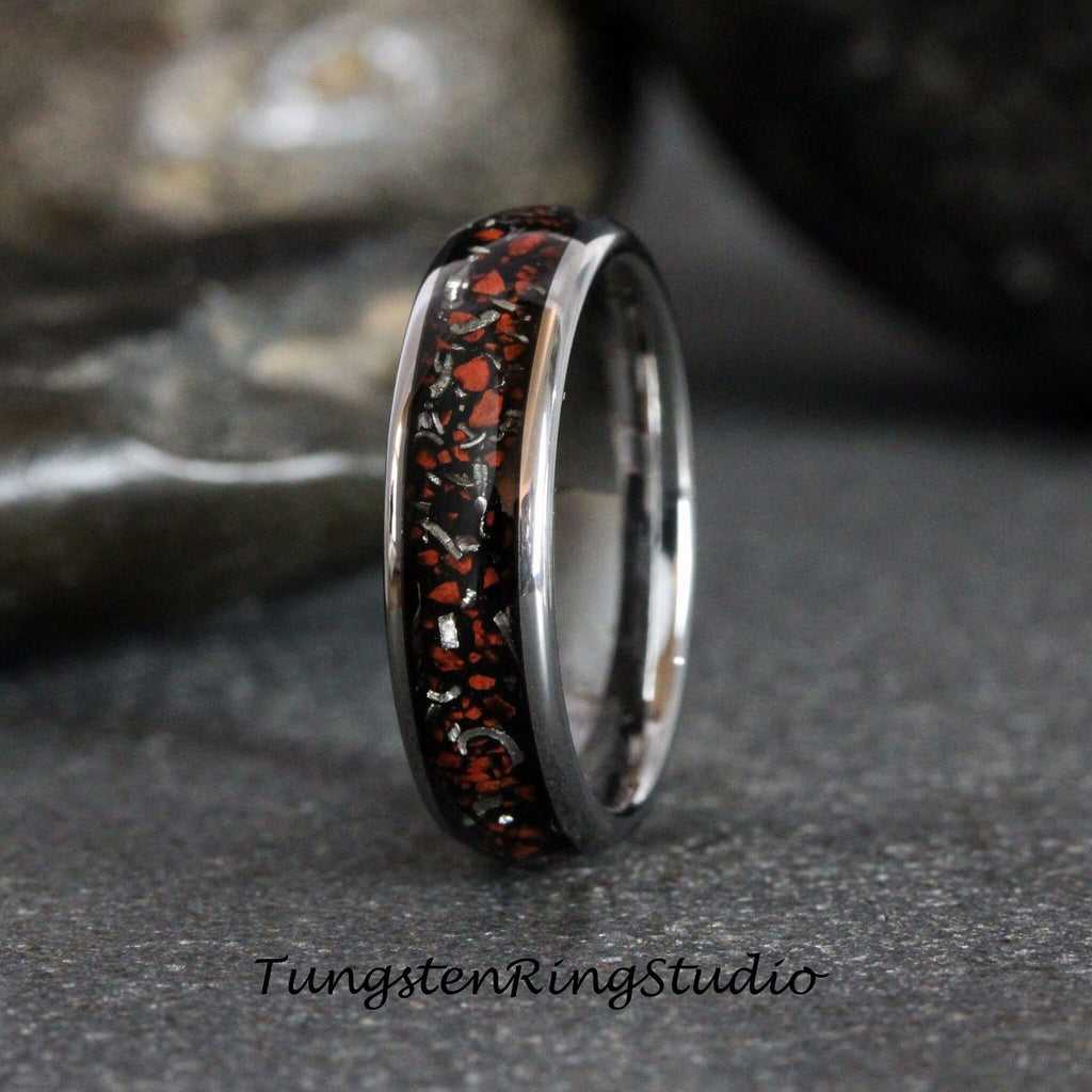 May include: A silver tungsten ring with a black and red inlay. The inlay has a speckled pattern of red and silver.