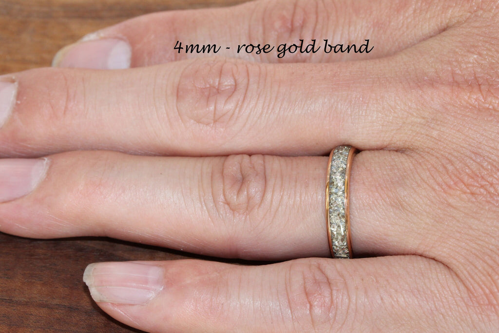 May include: A 4mm rose gold band with a row of small diamonds around the entire band.