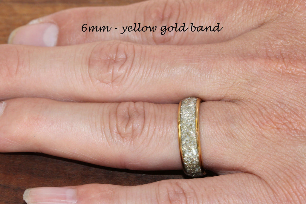May include: A 6mm yellow gold band with a row of small, clear stones around the edge.