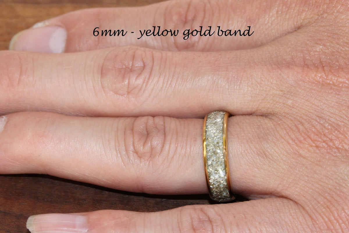 May include: A 6mm yellow gold band with a row of small, clear stones around the edge.