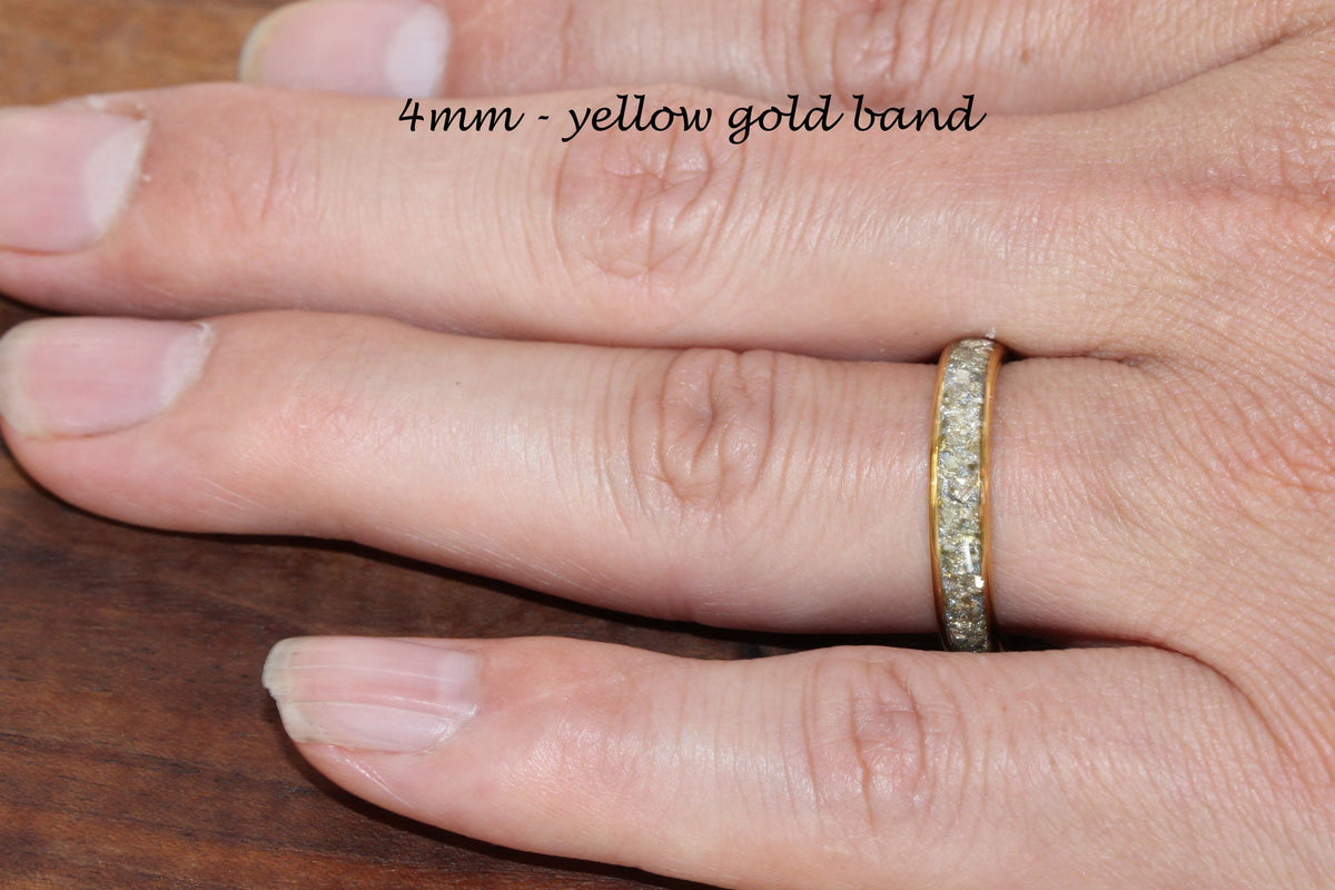 May include: A 4mm yellow gold band with a row of small diamonds around the entire band.