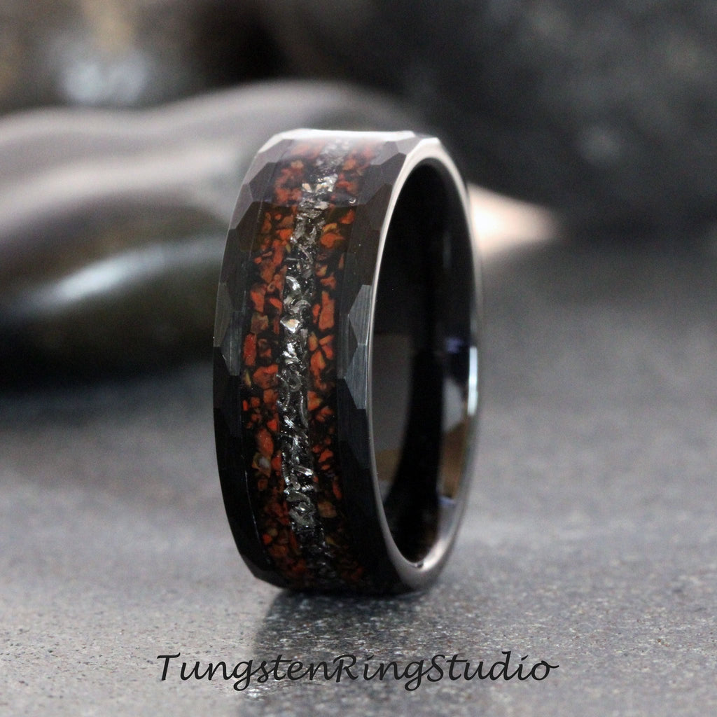 May include: A black tungsten carbide ring with a hammered finish and a red and silver inlay. The inlay is made of crushed stone and is set in a channel around the ring.