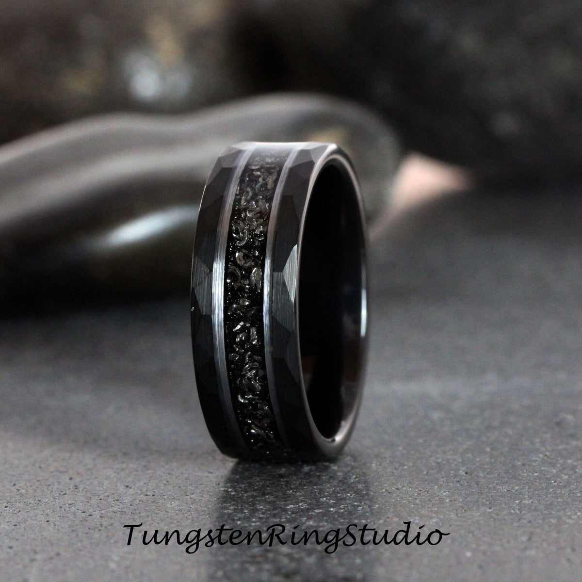 May include: Black tungsten carbide ring with a black inlay and a beveled edge.