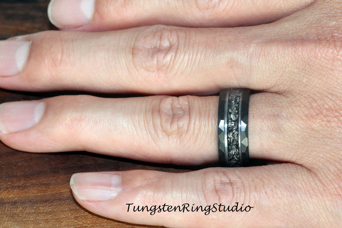 May include: A black tungsten carbide ring with a black and silver inlay. The ring has a beveled edge and a brushed finish.