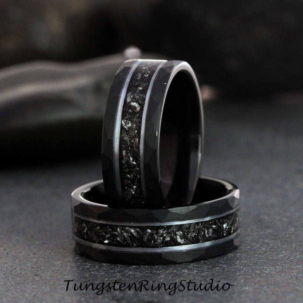 May include: Two black tungsten carbide rings with a hammered finish and a silver inlay. The rings are stacked on top of each other.